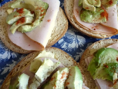 bagels cétogènes avec des tranches de blanc de poulet et d'avocat saupoudrés de paprika